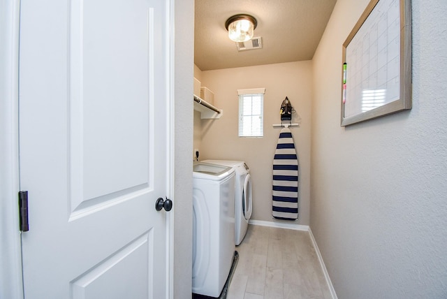 laundry room featuring laundry area, separate washer and dryer, visible vents, light wood-style floors, and baseboards