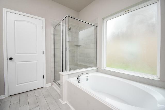 bathroom featuring a stall shower and a bath