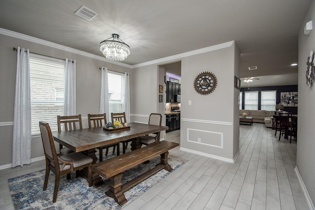 dining room featuring ceiling fan with notable chandelier, light wood-type flooring, visible vents, and crown molding