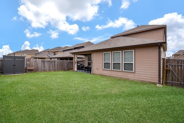 rear view of house featuring a yard, a patio, a shed, a fenced backyard, and an outdoor structure