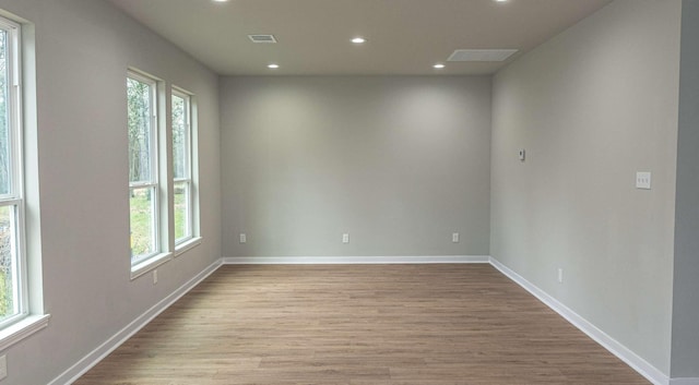 unfurnished room featuring light wood-style floors, recessed lighting, a healthy amount of sunlight, and visible vents