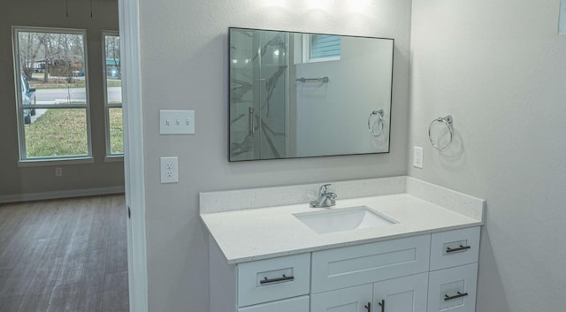 bathroom featuring vanity, baseboards, and wood finished floors