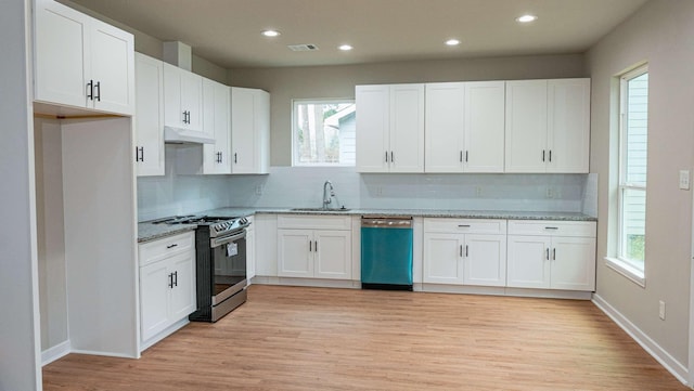 kitchen with stainless steel appliances, visible vents, white cabinetry, a sink, and under cabinet range hood