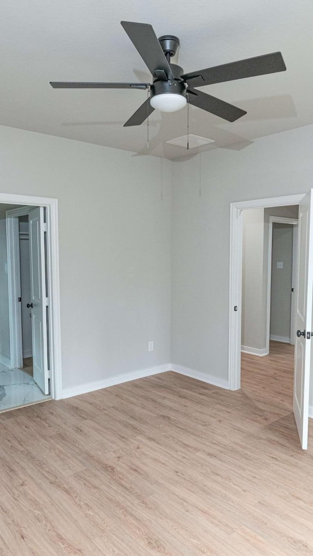 empty room with light wood-style floors, baseboards, and a ceiling fan