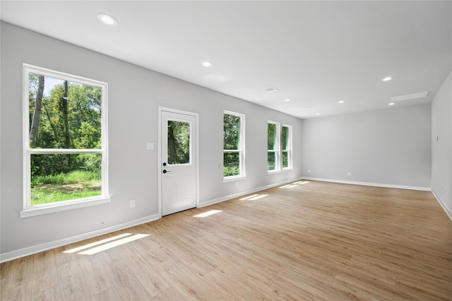 unfurnished living room featuring light wood-type flooring, baseboards, and recessed lighting