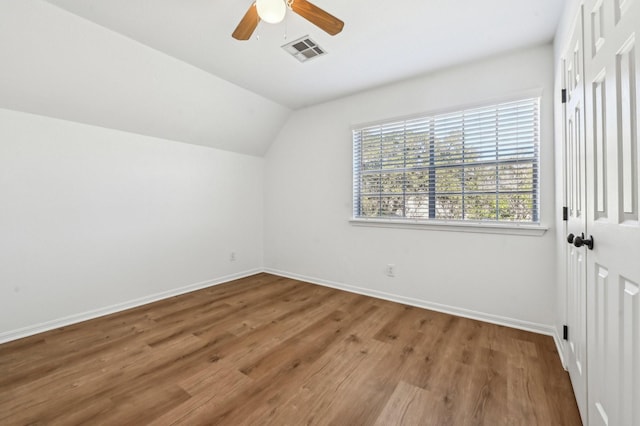 additional living space featuring lofted ceiling, baseboards, visible vents, and wood finished floors