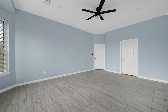 spare room featuring wood finish floors, crown molding, visible vents, a ceiling fan, and baseboards