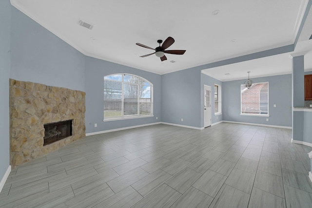 unfurnished living room with ceiling fan with notable chandelier, a fireplace, visible vents, baseboards, and crown molding