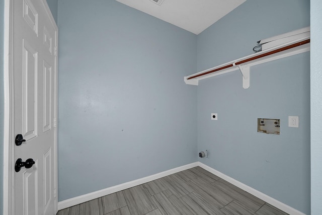 clothes washing area featuring wood finish floors, hookup for a washing machine, hookup for an electric dryer, laundry area, and baseboards