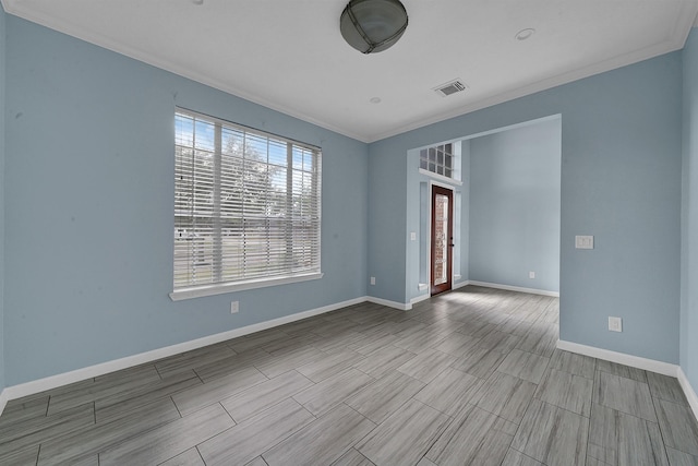 unfurnished room featuring baseboards, wood tiled floor, visible vents, and ornamental molding