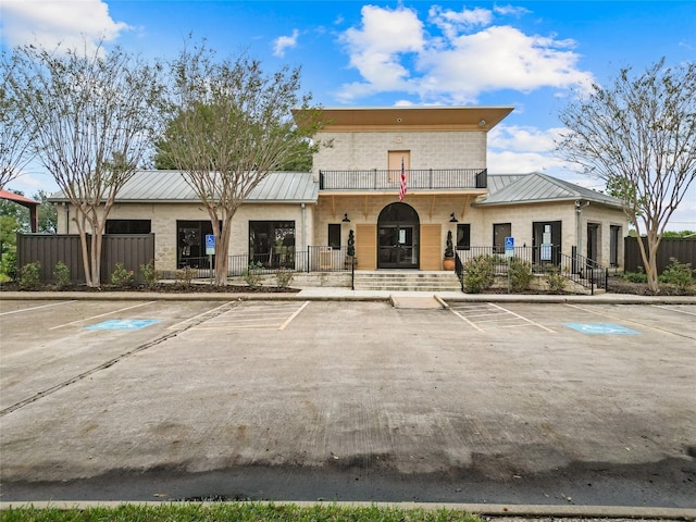 view of building exterior featuring uncovered parking and fence