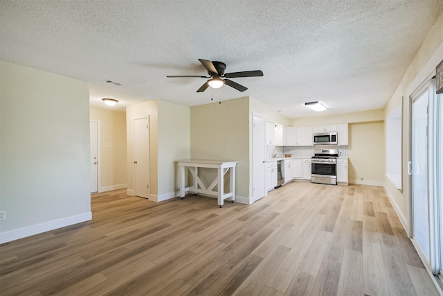 19823 Burle Oak Dr, Humble, TX 77346 - kitchen featuring light wood finished floors, visible vents, white cabinetry, and stainless steel appliances