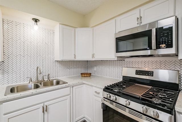 19823 Burle Oak Dr, Humble, TX 77346 - kitchen featuring a sink, white cabinets, tasteful backsplash, and stainless steel appliances
