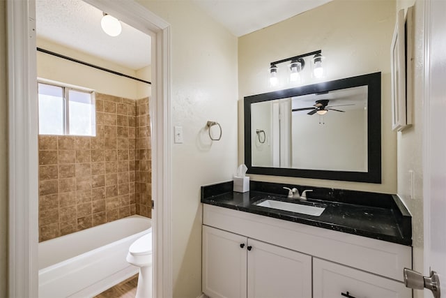 full bath featuring bathing tub / shower combination, vanity, toilet, and a ceiling fan