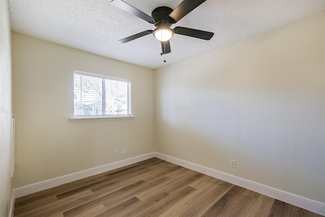 unfurnished room featuring a textured ceiling, wood finished floors, a ceiling fan, and baseboards