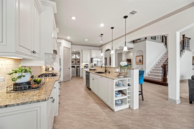 kitchen featuring hanging light fixtures, white cabinets, open shelves, and a large island with sink