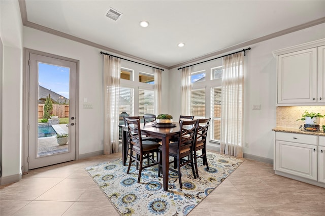 dining space with baseboards, light tile patterned floors, visible vents, and crown molding