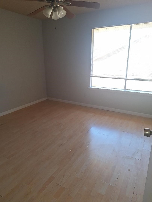 unfurnished room featuring light wood finished floors, ceiling fan, and baseboards