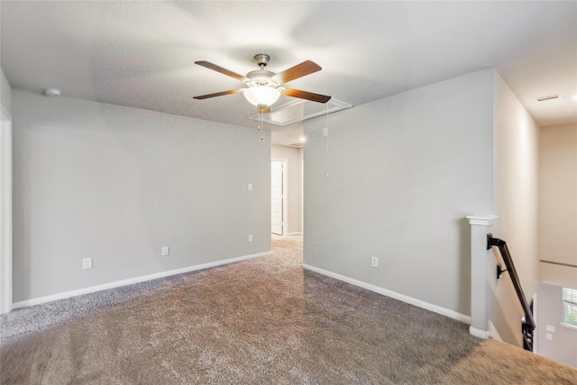 spare room featuring carpet, attic access, and baseboards