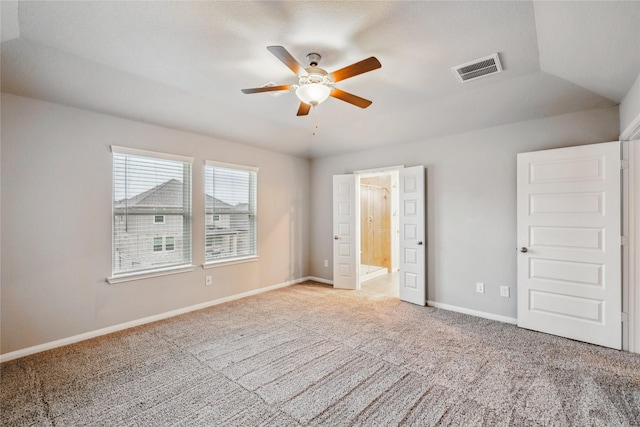 unfurnished bedroom with connected bathroom, carpet flooring, visible vents, baseboards, and vaulted ceiling