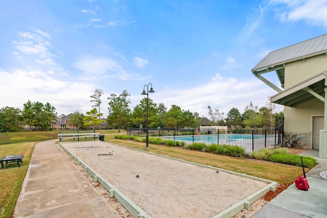 view of home's community featuring a lawn, fence, and a pool