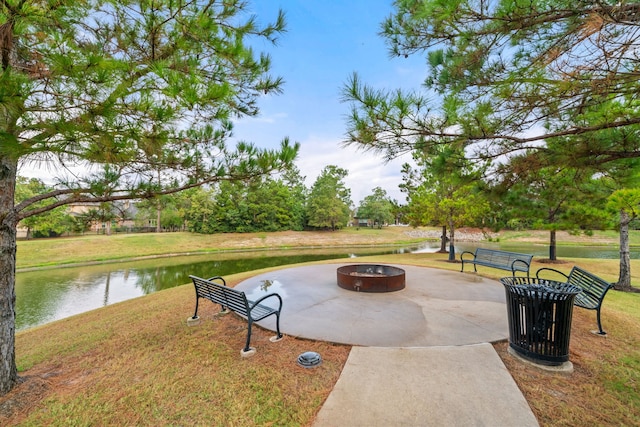 view of property's community featuring a fire pit, a patio, a lawn, and a water view