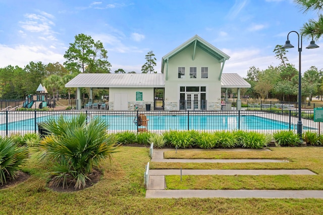 pool featuring a yard, playground community, and fence