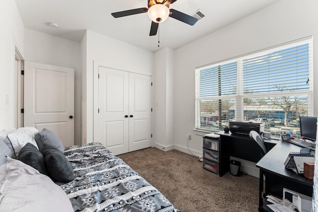 bedroom featuring baseboards, visible vents, ceiling fan, dark colored carpet, and a closet