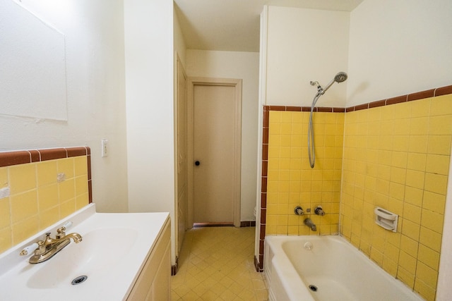 full bath featuring shower / bathtub combination, vanity, and tile walls