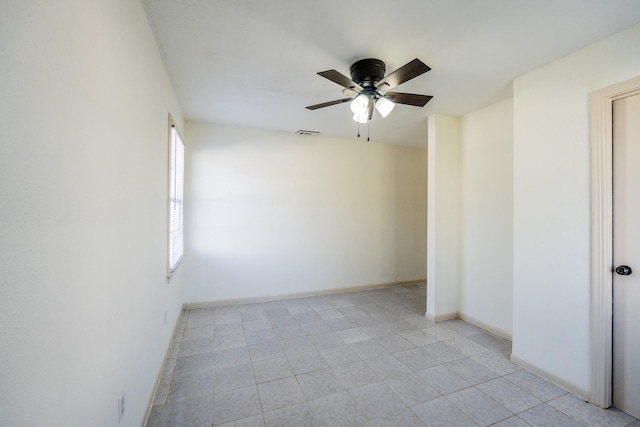 spare room with visible vents, ceiling fan, and baseboards