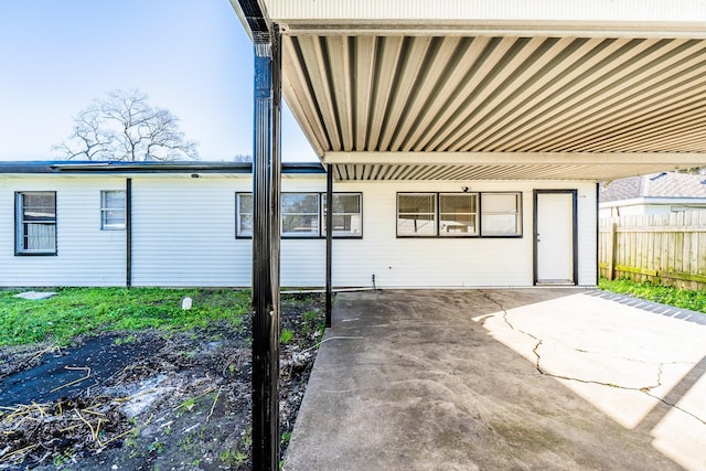 view of patio / terrace with a carport and fence