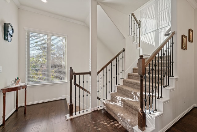 stairs with a wealth of natural light, ornamental molding, and wood finished floors