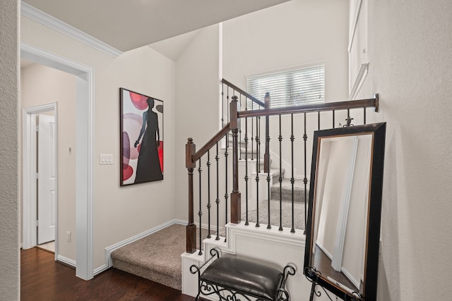 stairway with crown molding, baseboards, and wood finished floors