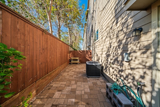 view of side of home featuring cooling unit, a patio area, and a fenced backyard