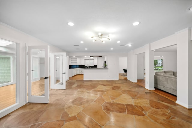 kitchen with recessed lighting, open floor plan, white cabinetry, and crown molding