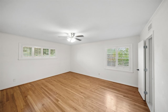 empty room with baseboards, visible vents, a ceiling fan, and light wood-style floors