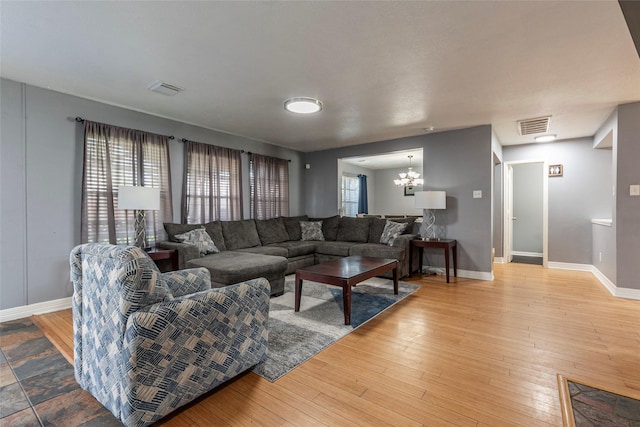 living room featuring visible vents, baseboards, and wood finished floors