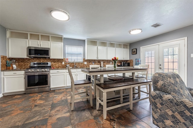 kitchen featuring visible vents, appliances with stainless steel finishes, and white cabinets