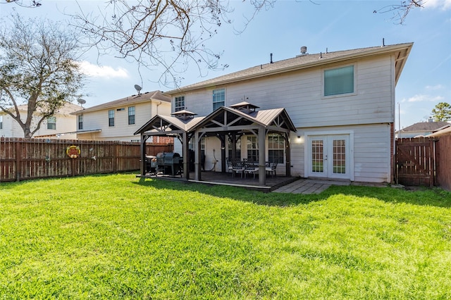 back of house featuring french doors, a fenced backyard, a yard, and a gazebo