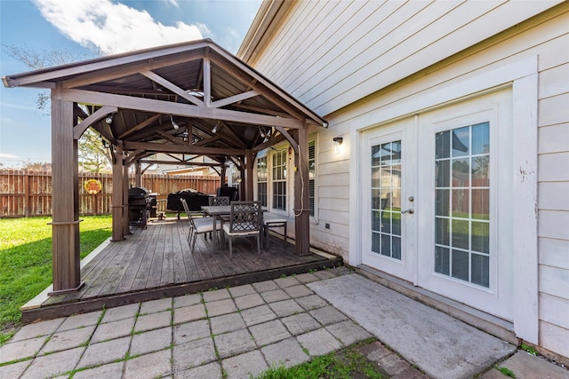 deck with outdoor dining area, a grill, fence, a gazebo, and french doors