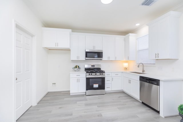 kitchen featuring stainless steel appliances, white cabinetry, and a sink