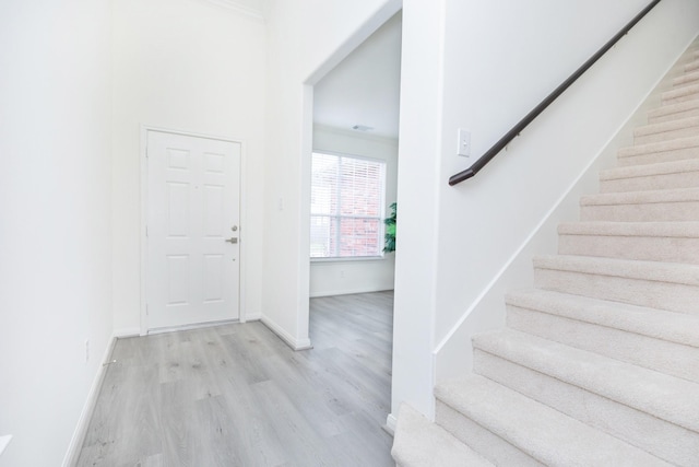 staircase with wood finished floors and baseboards