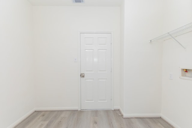 clothes washing area with washer hookup, visible vents, light wood-style floors, laundry area, and baseboards