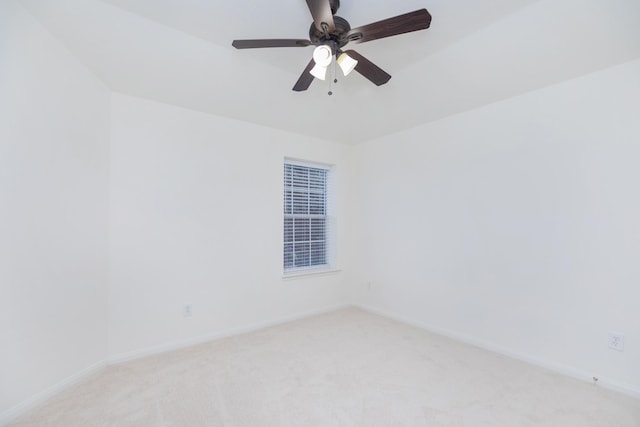 spare room with light carpet, ceiling fan, and baseboards