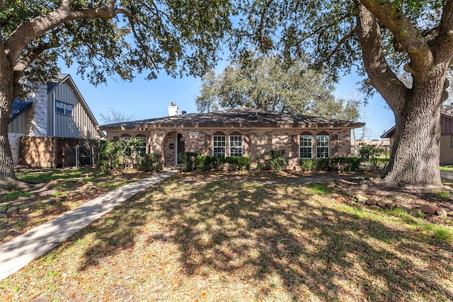 single story home with a front lawn and a chimney