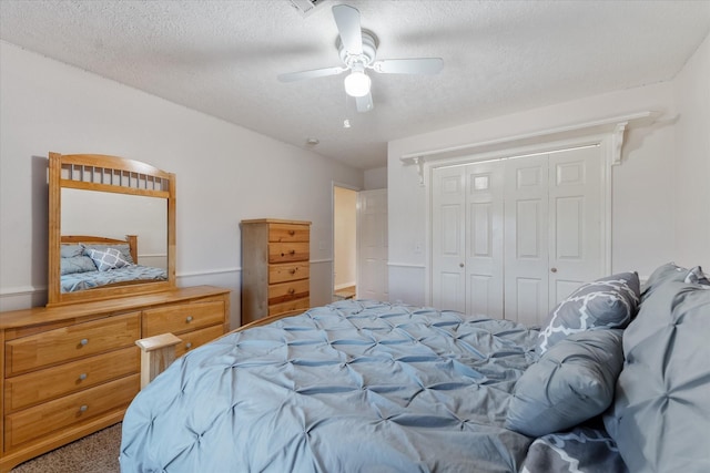 bedroom featuring a closet, carpet flooring, ceiling fan, and a textured ceiling