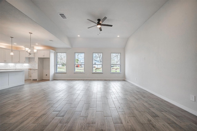 24690 Galway St, Hempstead, TX 77445 - unfurnished living room featuring baseboards, visible vents, light wood finished floors, and ceiling fan with notable chandelier