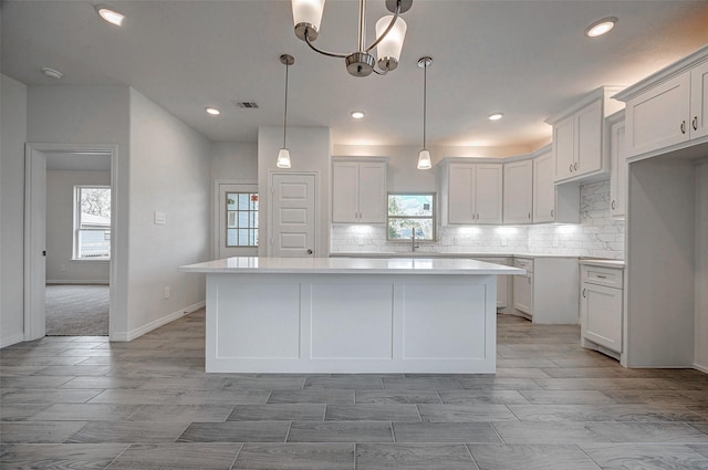 24690 Galway St, Hempstead, TX 77445 - kitchen with visible vents, a kitchen island, light countertops, white cabinetry, and pendant lighting