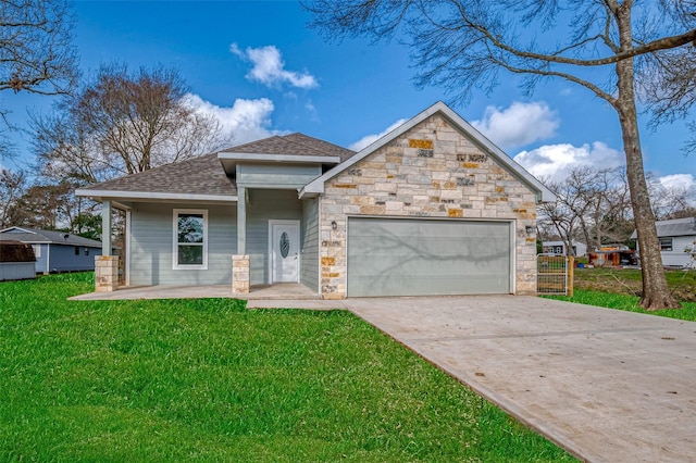 view of front of house featuring driveway, a garage, a shingled roof, stone siding, and a front yard