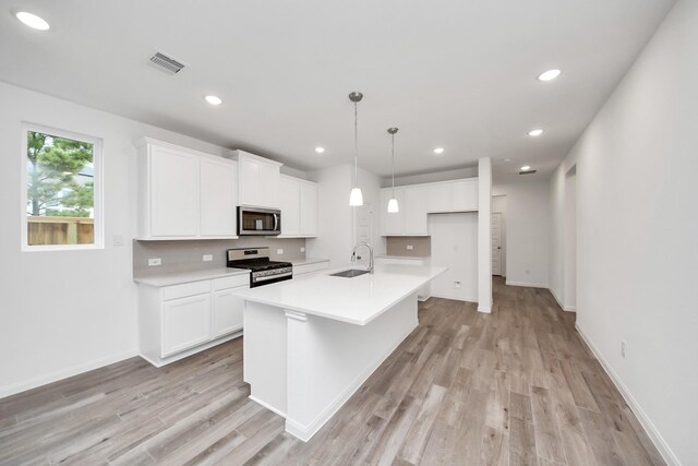 24727 Harrow Meadow Dr, Katy, TX 77493 - kitchen featuring a sink, light countertops, light wood-type flooring, white cabinetry, and stainless steel appliances